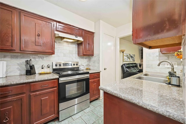 kitchen featuring stainless steel range with electric stovetop, a sink, under cabinet range hood, light tile patterned flooring, and tasteful backsplash
