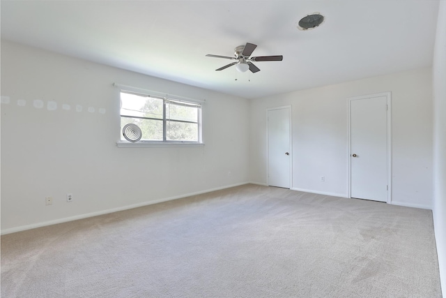 unfurnished bedroom with baseboards, light colored carpet, and ceiling fan