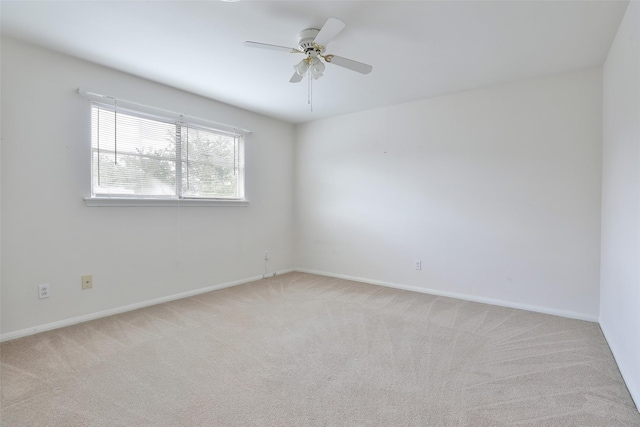unfurnished room with light colored carpet, ceiling fan, and baseboards
