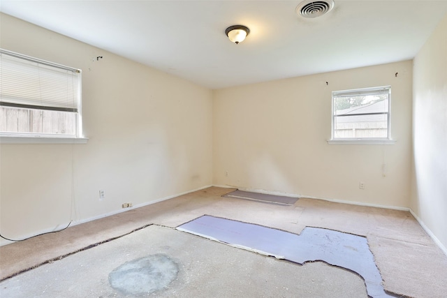 carpeted empty room featuring baseboards and visible vents