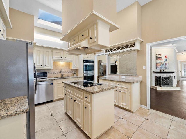 6729 Tournament Dr, Houston, TX 77069 - kitchen with appliances with stainless steel finishes, light tile patterned flooring, tasteful backsplash, cream cabinets, and a kitchen island