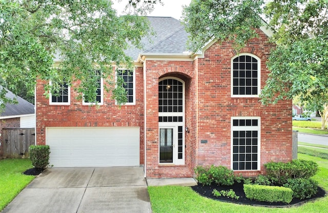 view of front facade with driveway, a shingled roof, and brick siding
