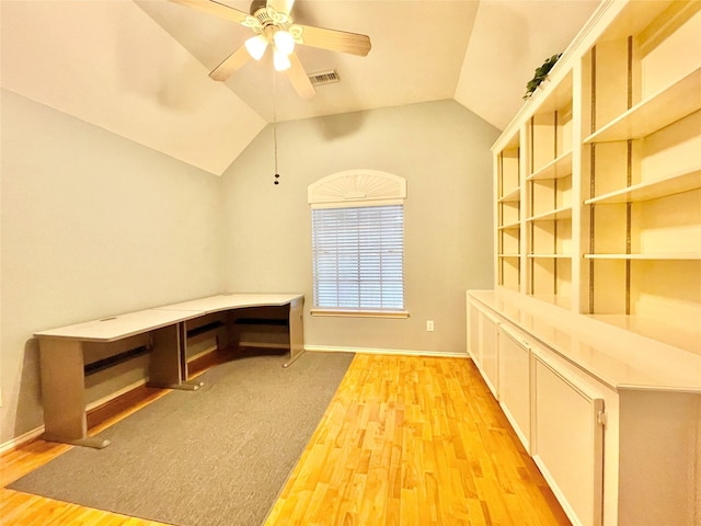 unfurnished office featuring a ceiling fan, visible vents, vaulted ceiling, and light wood-type flooring