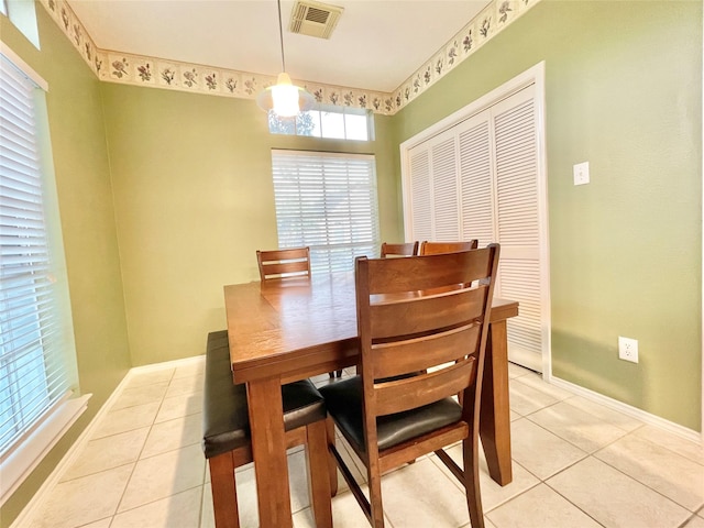 dining room featuring light tile patterned flooring, visible vents, and baseboards