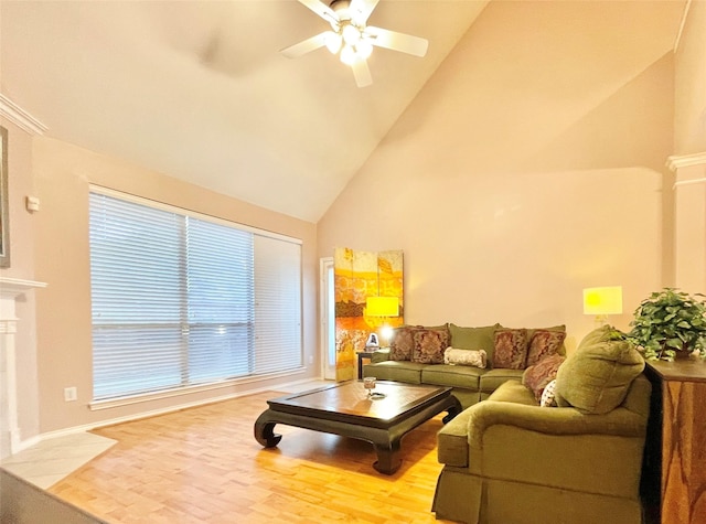 living area with a tiled fireplace, high vaulted ceiling, wood finished floors, and a ceiling fan