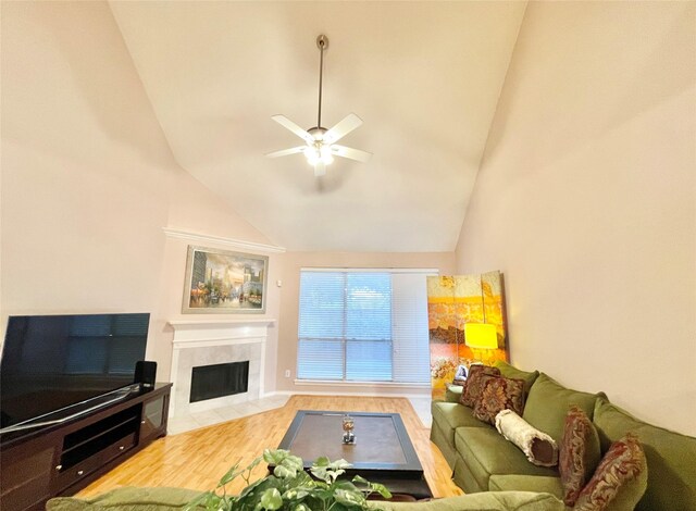 living room with a ceiling fan, wood finished floors, lofted ceiling, and a fireplace