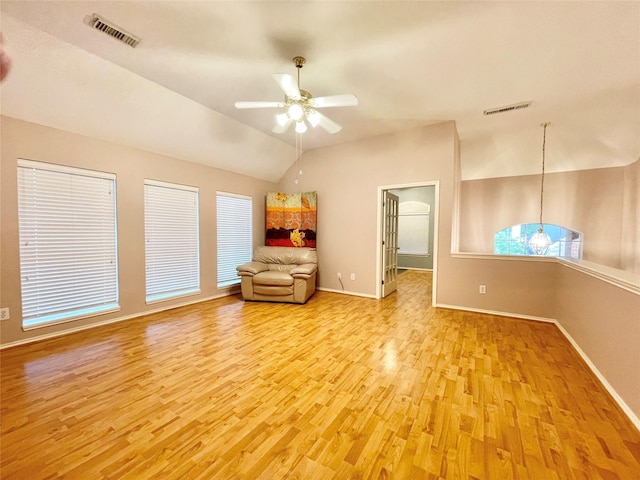 unfurnished room with visible vents, light wood-type flooring, ceiling fan, and lofted ceiling