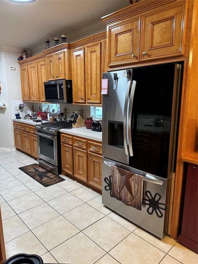 kitchen featuring light tile patterned floors, brown cabinets, crown molding, appliances with stainless steel finishes, and light countertops