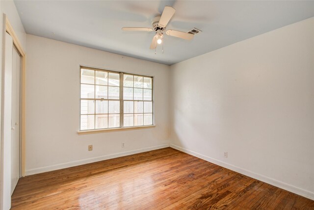 unfurnished bedroom featuring baseboards, wood finished floors, visible vents, and a closet