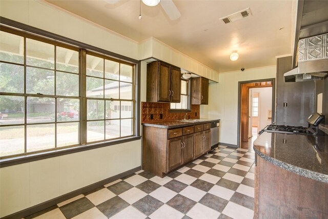 kitchen with dark brown cabinetry, visible vents, dark floors, stainless steel dishwasher, and dark countertops