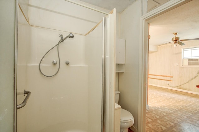 bathroom featuring toilet, cooling unit, ceiling fan, and a shower stall