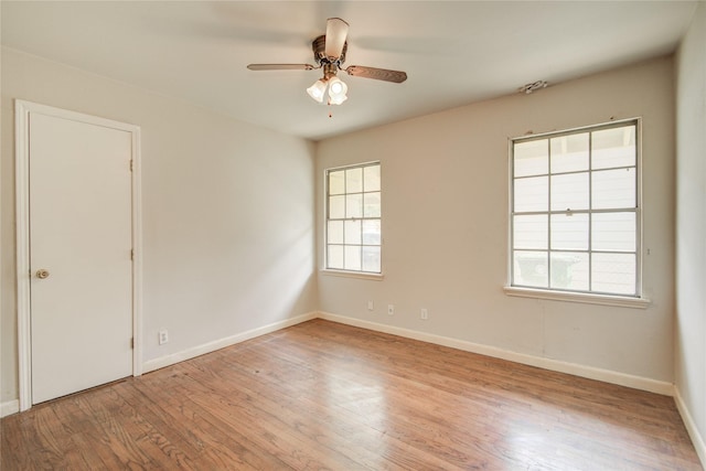 unfurnished room featuring baseboards, wood finished floors, and ceiling fan