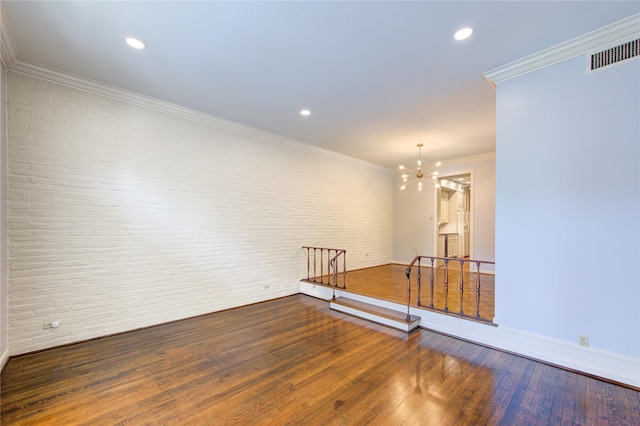 7530 Del Monte Dr, Houston, TX 77063 - empty room with brick wall, a chandelier, baseboards, wood finished floors, and visible vents