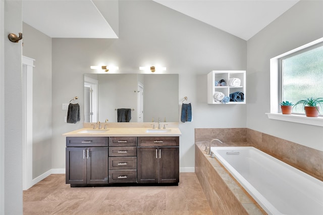 full bath featuring a sink, a bath, double vanity, and lofted ceiling