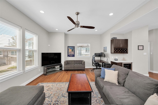 living room featuring recessed lighting, indoor bar, a ceiling fan, and light wood finished floors