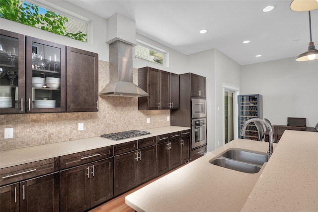 kitchen with a sink, decorative backsplash, appliances with stainless steel finishes, and decorative light fixtures