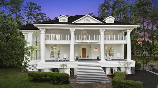 rear view of property featuring a porch, a balcony, and stairway