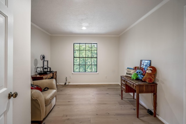 living area featuring light wood-style flooring, baseboards, a textured ceiling, and ornamental molding