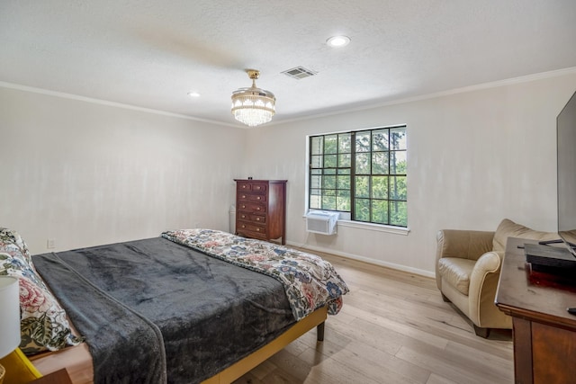 bedroom with light wood finished floors, visible vents, ornamental molding, baseboards, and a notable chandelier