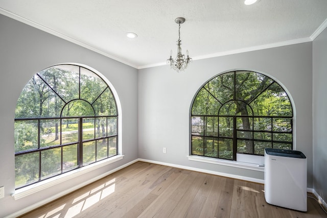 unfurnished dining area featuring wood-type flooring, baseboards, recessed lighting, and an inviting chandelier