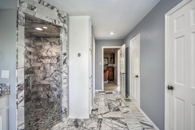 corridor with recessed lighting, marble finish floor, and baseboards