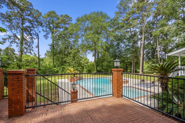 view of gate with fence, a patio area, and a fenced in pool