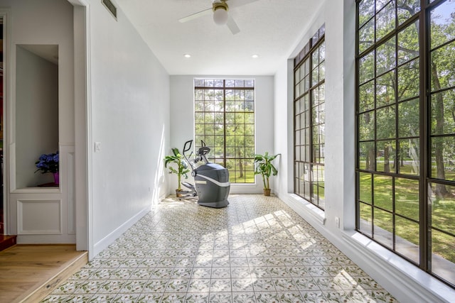 17003 Creeksouth Rd, Houston, TX 77068 - living area featuring a ceiling fan, a decorative wall, and a wainscoted wall