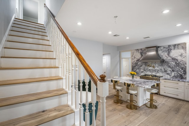 stairs featuring recessed lighting, wood finished floors, and visible vents
