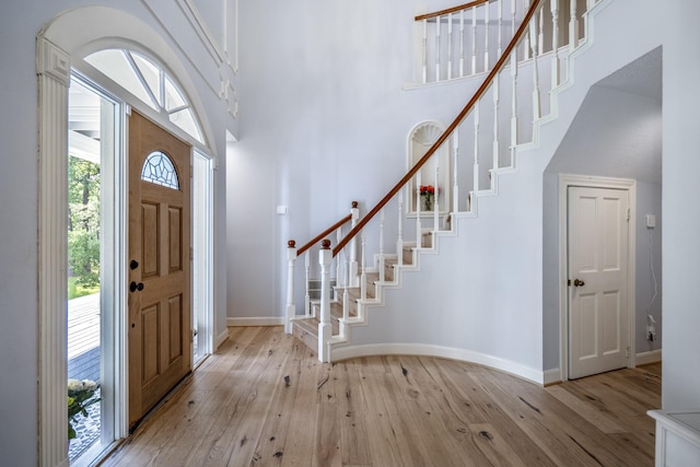 17003 Creeksouth Rd, Houston, TX 77068 - entryway with a towering ceiling, light wood-style flooring, baseboards, and stairs