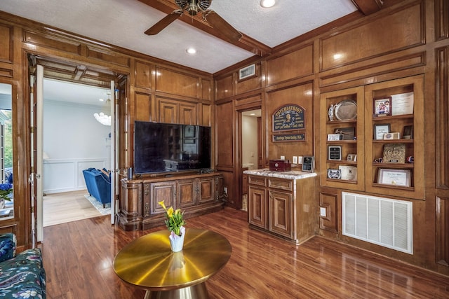 17003 Creeksouth Rd, Houston, TX 77068 - living area with a decorative wall, a ceiling fan, dark wood-type flooring, ornamental molding, and built in shelves