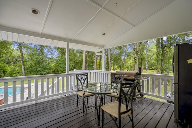 deck with an outdoor pool, outdoor dining space, and area for grilling