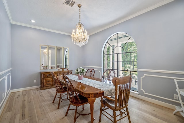 dining area featuring light wood finished floors, visible vents, a notable chandelier, and ornamental molding
