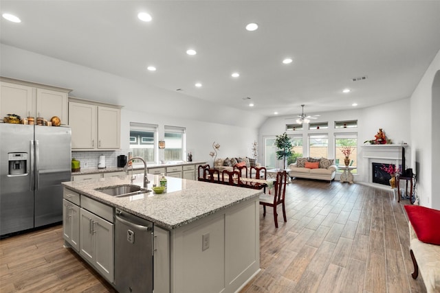 6930 Goldstrum Way, Katy, TX 77493 - kitchen with a healthy amount of sunlight, an island with sink, stainless steel appliances, and a sink