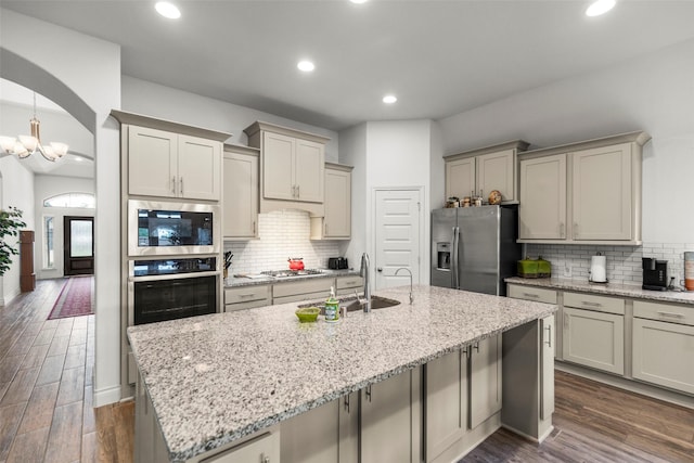6930 Goldstrum Way, Katy, TX 77493 - kitchen with recessed lighting, dark wood finished floors, stainless steel appliances, a kitchen island with sink, and tasteful backsplash