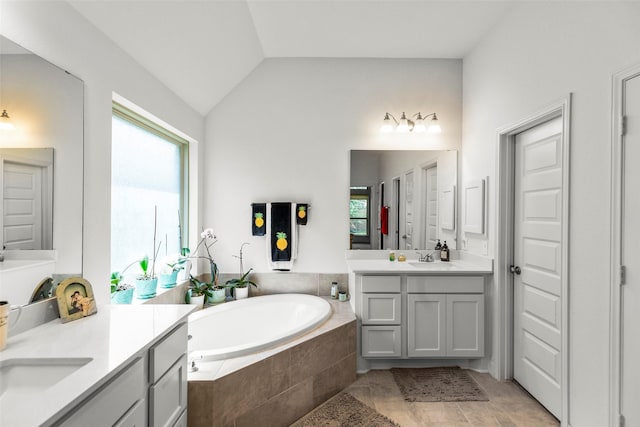 6930 Goldstrum Way, Katy, TX 77493 - bathroom featuring two vanities, a bath, vaulted ceiling, and a sink
