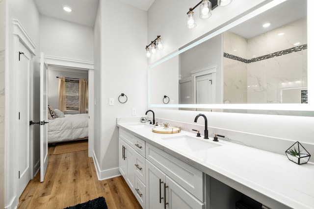 full bath with connected bathroom, wood finished floors, a sink, and double vanity