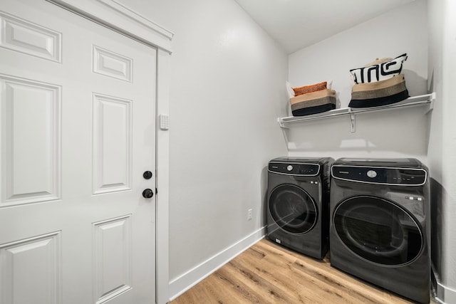 laundry room featuring washing machine and dryer, light wood-type flooring, baseboards, and laundry area