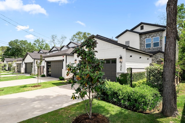 view of front of property featuring concrete driveway, stone siding, a front yard, and a garage