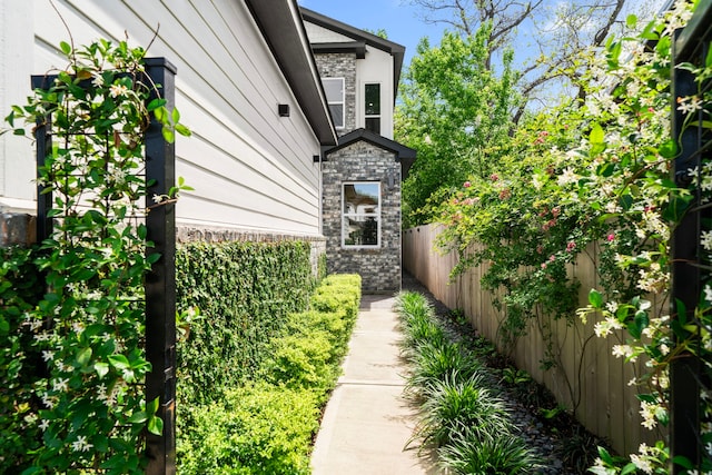 view of property exterior featuring fence private yard and stone siding