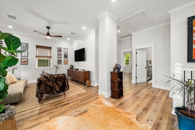 living area with attic access, wood finished floors, visible vents, and ceiling fan