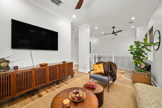 living room with a ceiling fan, visible vents, and ornamental molding