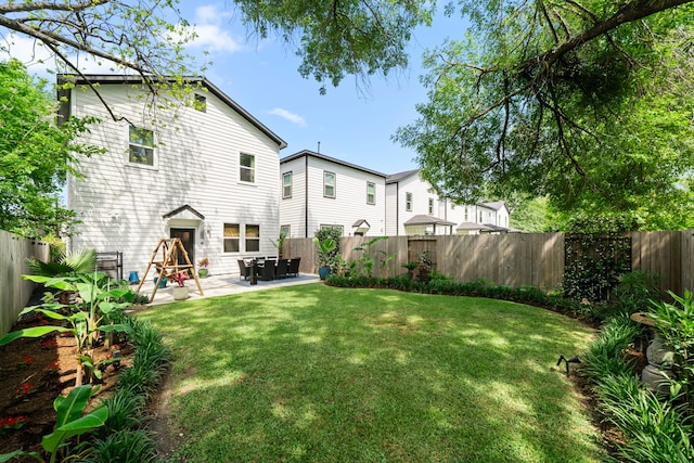 rear view of property with a yard, a fenced backyard, and a patio