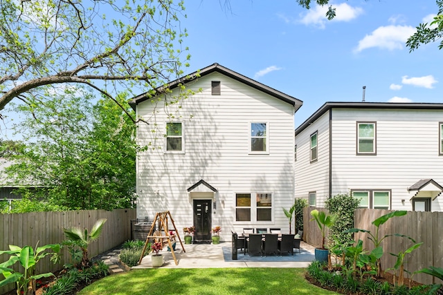 rear view of house featuring a lawn, a fenced backyard, and a patio