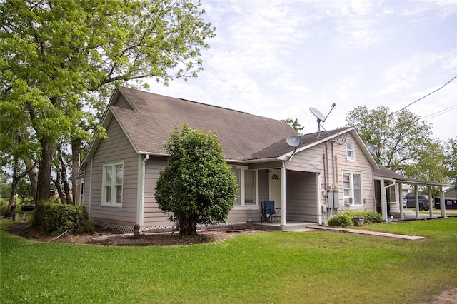ranch-style house featuring roof with shingles and a front yard
