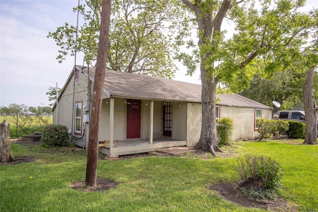 single story home featuring a porch, a front yard, and a shingled roof