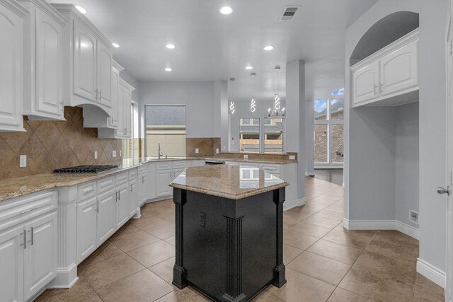 13811 Sugar Dock Ct, Houston, TX 77044 - kitchen with plenty of natural light, stainless steel gas cooktop, backsplash, white cabinets, and recessed lighting
