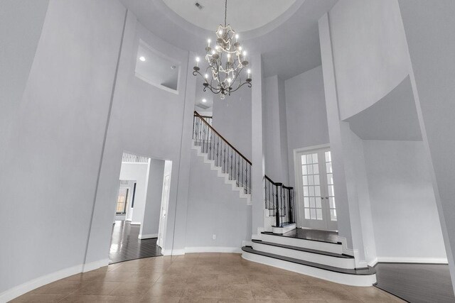 13811 Sugar Dock Ct, Houston, TX 77044 - stairway with a high ceiling, a chandelier, and tile patterned floors