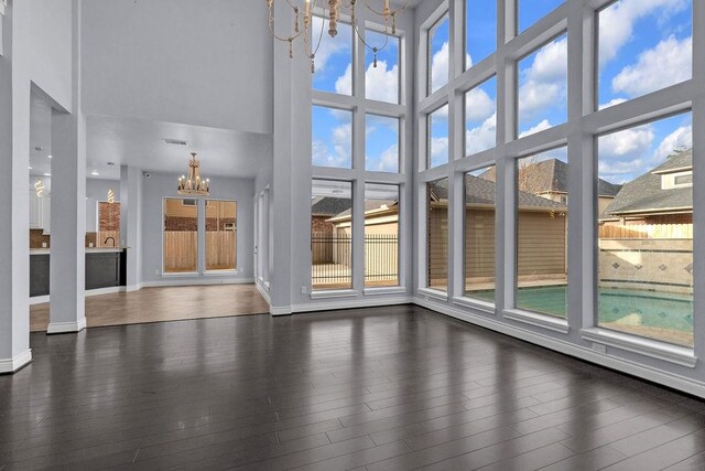 13811 Sugar Dock Ct, Houston, TX 77044 - unfurnished living room with a chandelier, a high ceiling, and dark wood-style floors