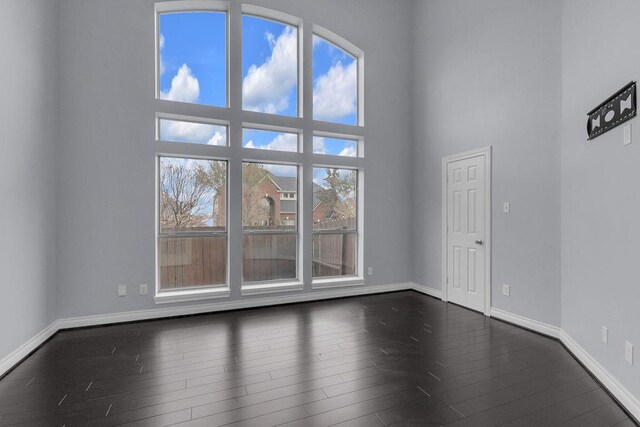 13811 Sugar Dock Ct, Houston, TX 77044 - empty room featuring dark wood-style flooring and a towering ceiling