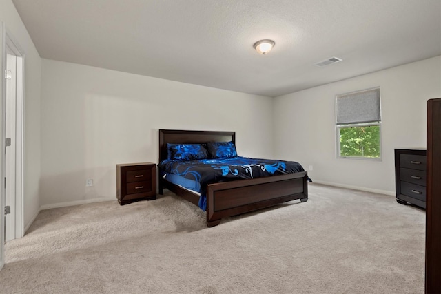 carpeted bedroom with visible vents and baseboards